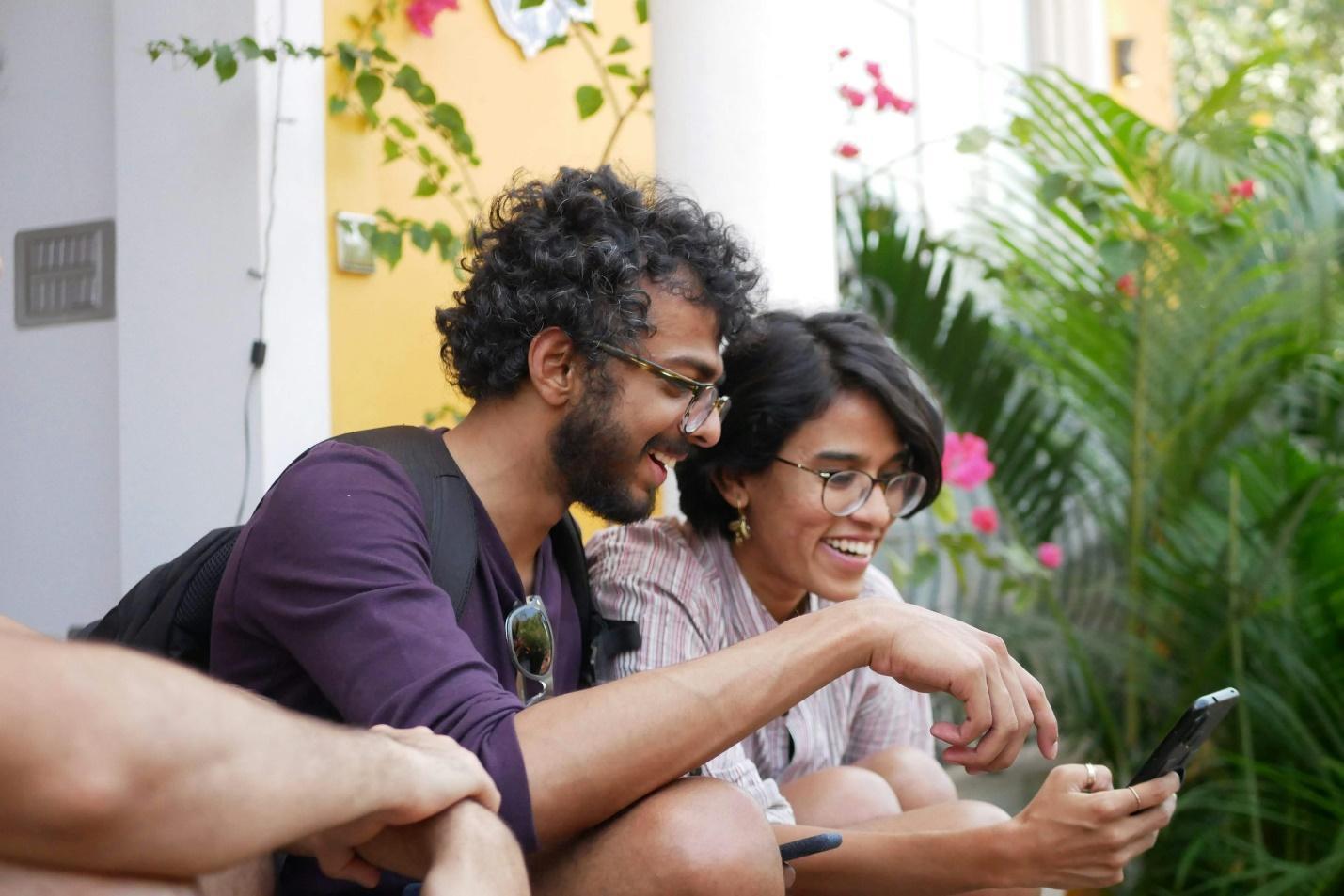 Man in the black polo shirt who sits next to a woman in the purple shirt