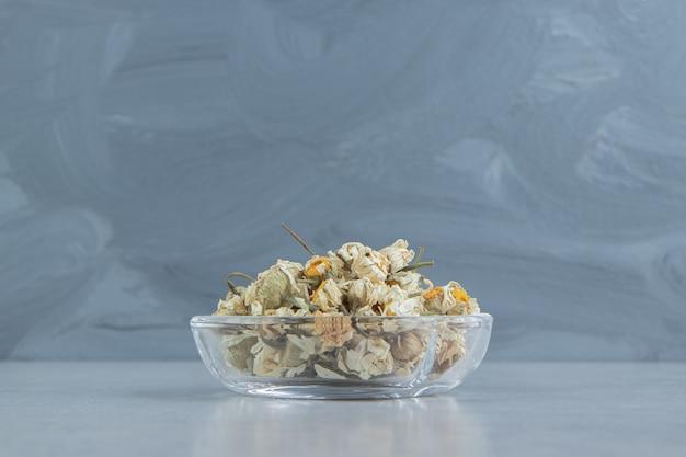 Dried chamomile flowers in the glass bowl.  